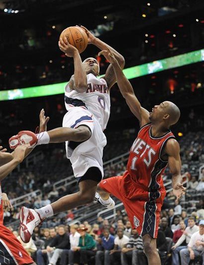 Jeff Teague jumps over the Nets' Rafer Alston
